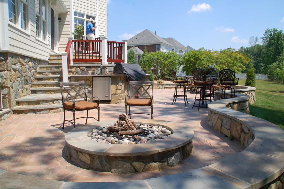 Design ideas for a large modern back patio in DC Metro with natural stone paving, no cover and a water feature.