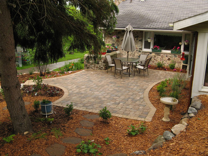 Design ideas for a medium sized rustic back patio in Milwaukee with brick paving and no cover.
