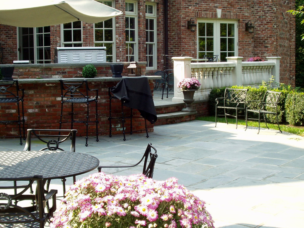 Modelo de patio clásico renovado grande sin cubierta en patio trasero con cocina exterior y suelo de baldosas