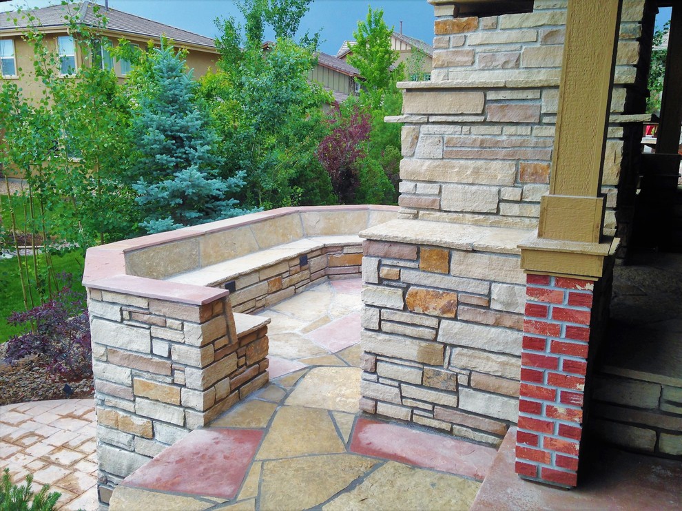 Idée de décoration pour une terrasse arrière design de taille moyenne avec une cheminée et des pavés en pierre naturelle.