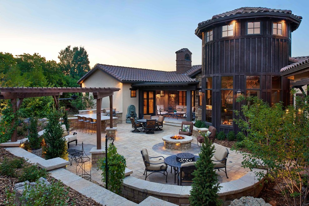 Photo of a medium sized contemporary back patio in Denver with a fire feature, natural stone paving and a pergola.