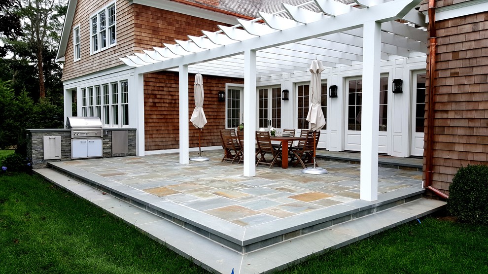 Diseño de patio clásico de tamaño medio en patio trasero con cocina exterior, adoquines de piedra natural y pérgola