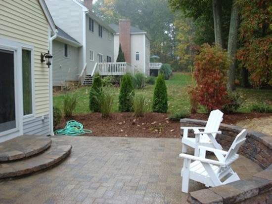 This is an example of a classic back patio in Bridgeport with brick paving and no cover.