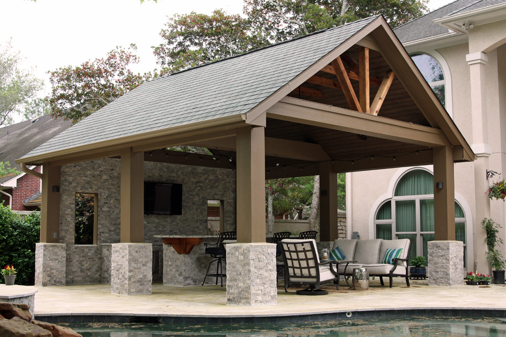 Foto di un grande patio o portico classico dietro casa con pavimentazioni in pietra naturale e un tetto a sbalzo