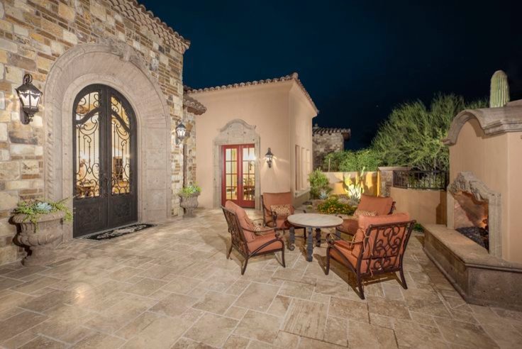 Photo of an expansive traditional back patio in Phoenix with natural stone paving.