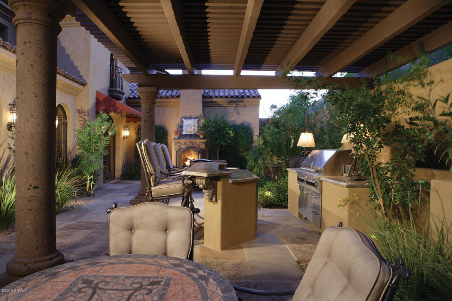 Esempio di un ampio patio o portico tradizionale dietro casa con pavimentazioni in pietra naturale e un tetto a sbalzo