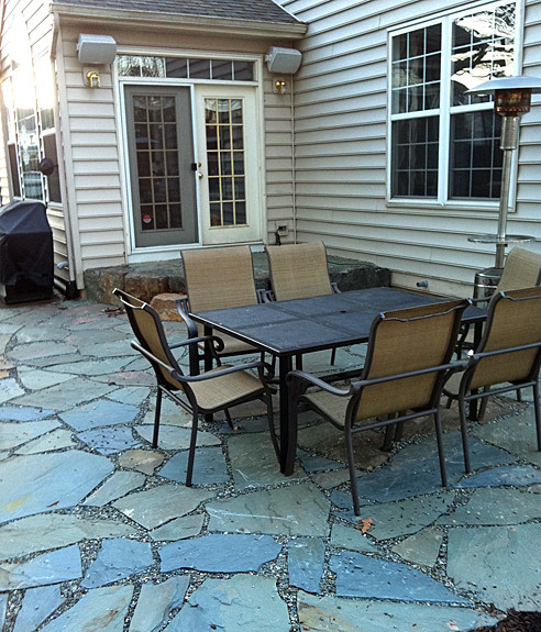 Imagen de patio clásico de tamaño medio sin cubierta en patio trasero con adoquines de piedra natural