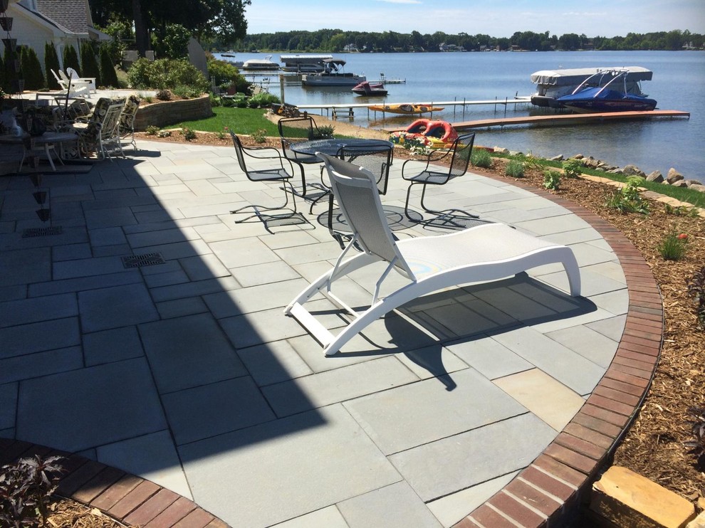 Photo of a traditional back patio in Grand Rapids with concrete paving and a roof extension.