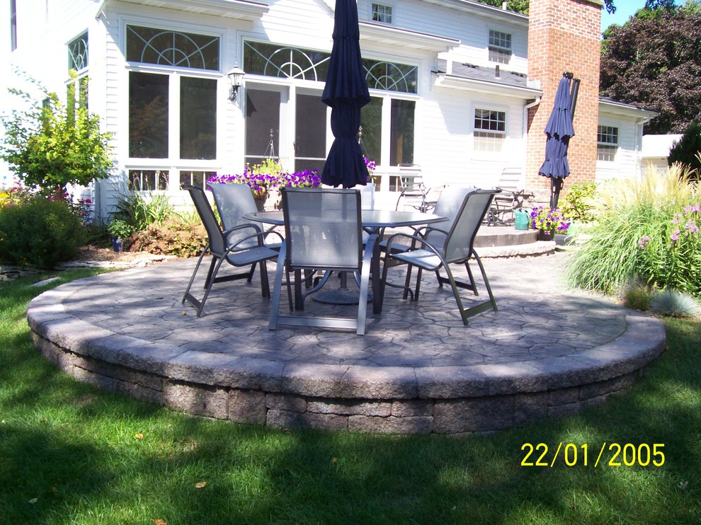 Esempio di un patio o portico tradizionale dietro casa con cemento stampato