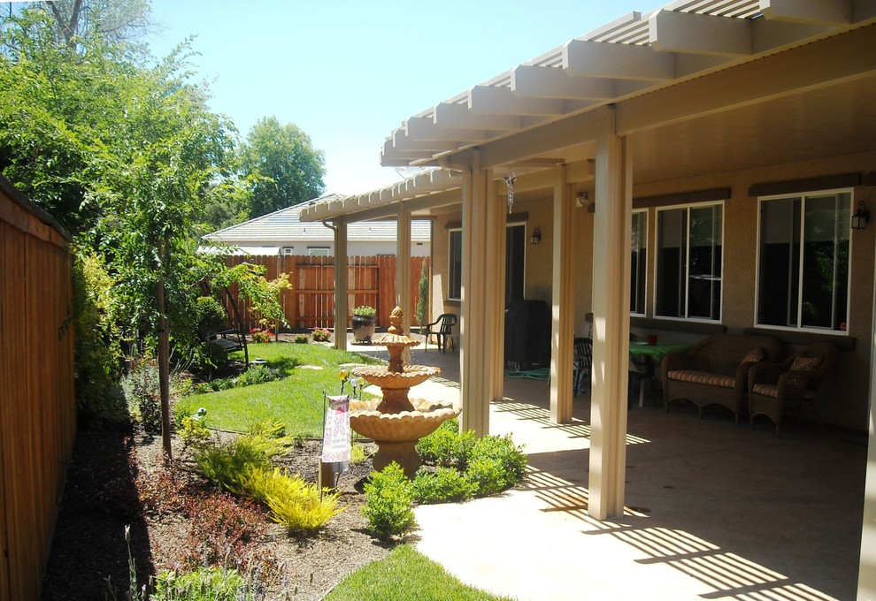 Immagine di un patio o portico classico di medie dimensioni e dietro casa con fontane e un parasole