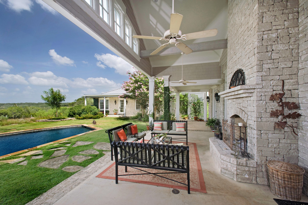 Design ideas for a traditional back patio in Austin with a roof extension and a fireplace.