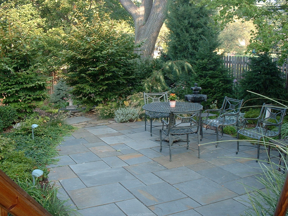 Inspiration for a mid-sized timeless backyard stone patio remodel in New York with no cover