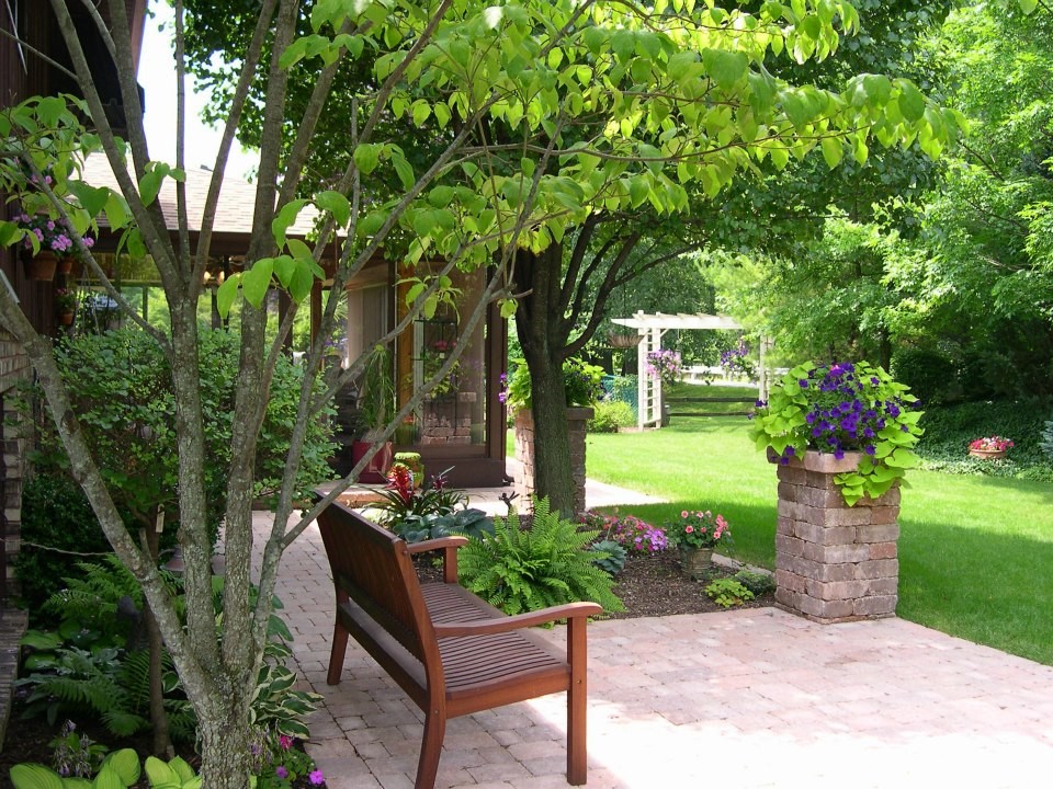 Ispirazione per un patio o portico classico di medie dimensioni e dietro casa con pavimentazioni in mattoni, nessuna copertura e un giardino in vaso