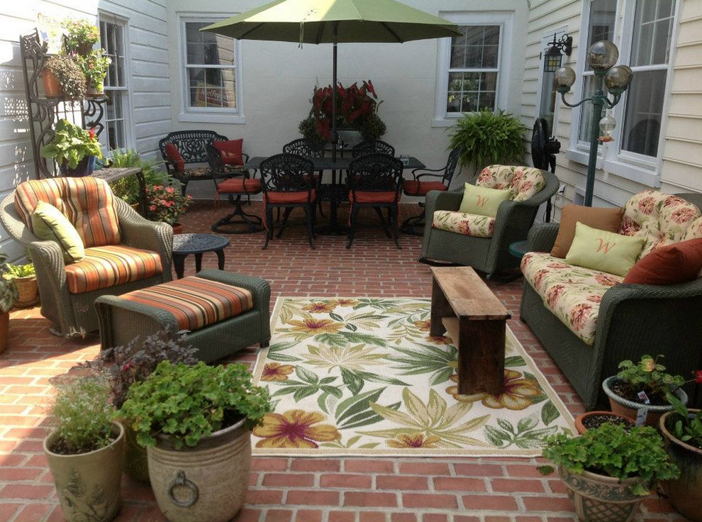Ejemplo de patio clásico de tamaño medio en patio trasero con adoquines de ladrillo