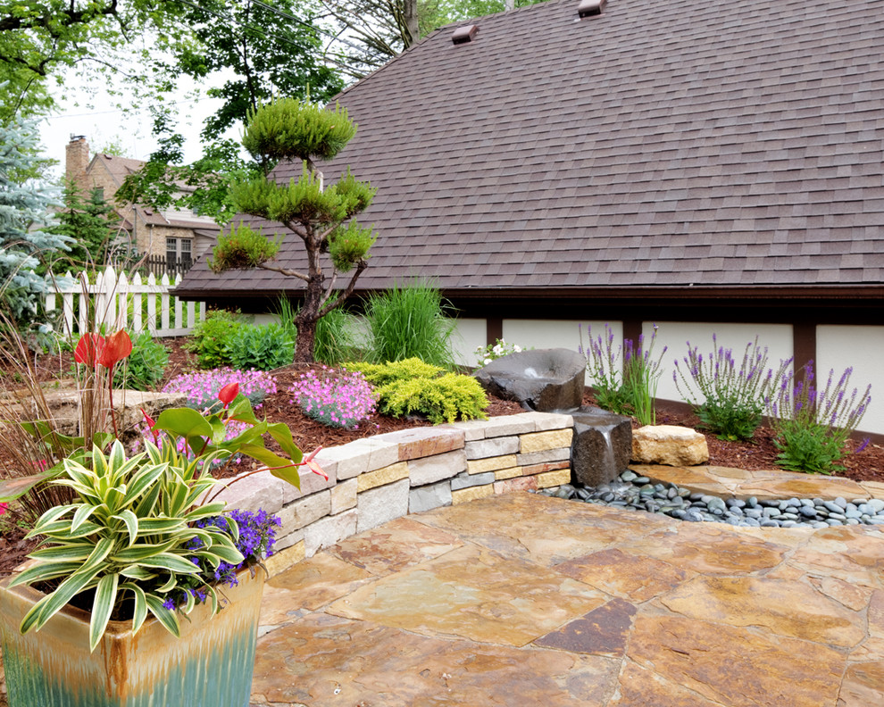 Idée de décoration pour une terrasse arrière vintage avec un point d'eau et des pavés en pierre naturelle.