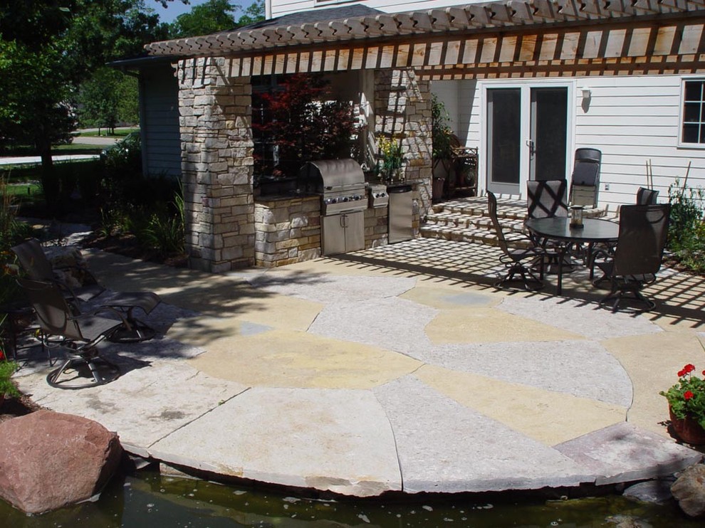 Large transitional backyard concrete paver patio kitchen photo in Other with a pergola