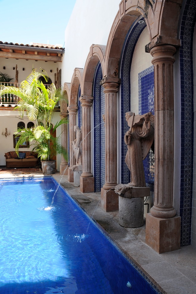 Ispirazione per una grande piscina mediterranea dietro casa con fontane e pavimentazioni in pietra naturale