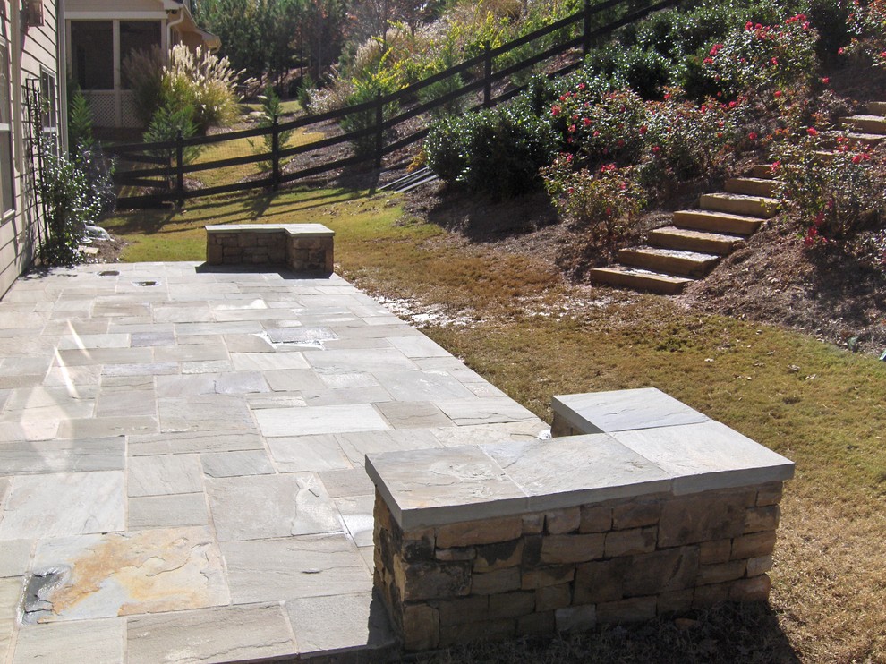 Diseño de patio clásico de tamaño medio sin cubierta en patio trasero con jardín vertical y adoquines de piedra natural