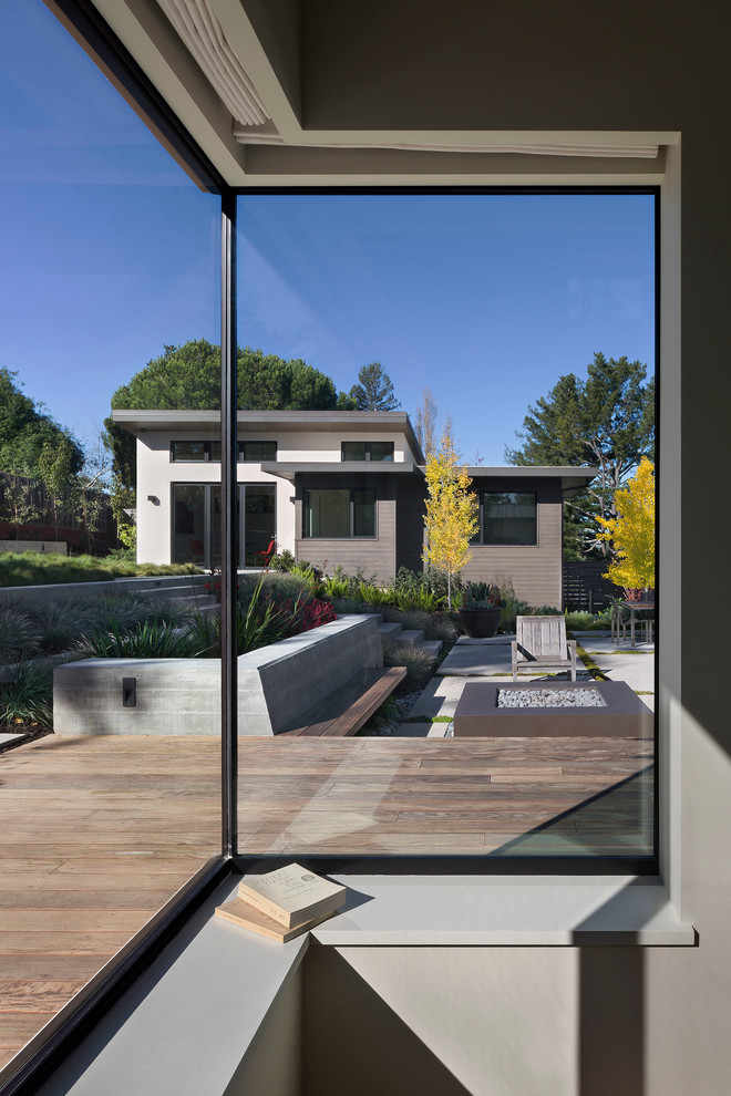 Idee per un ampio patio o portico minimal dietro casa con un focolare, lastre di cemento e nessuna copertura
