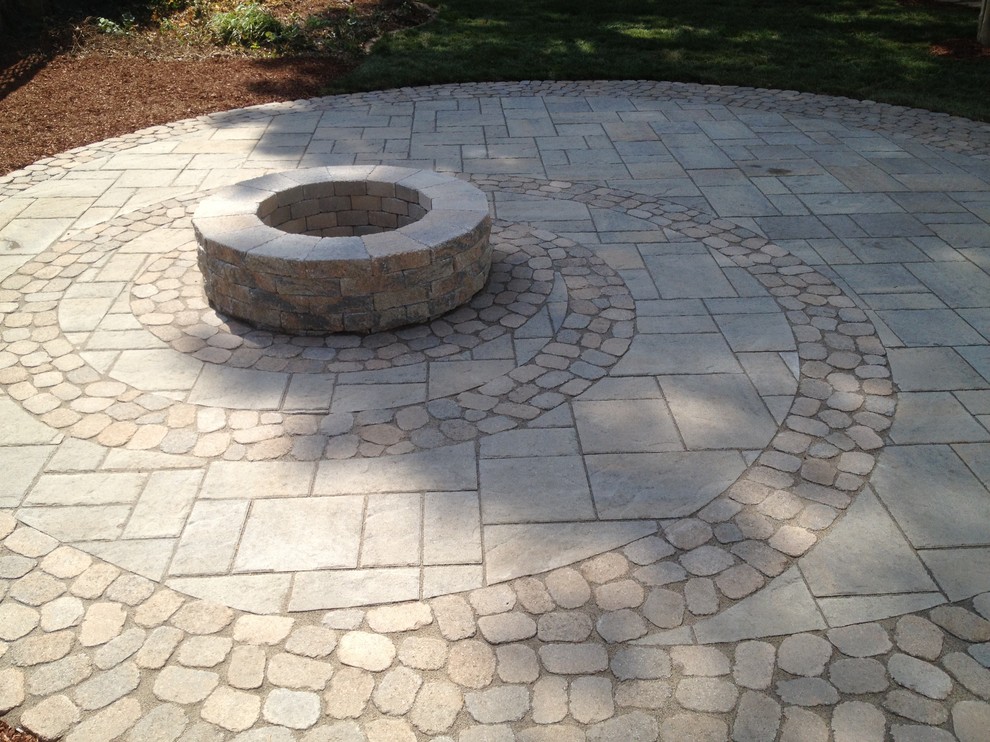 Medium sized eclectic back patio in Richmond with a fire feature, natural stone paving and no cover.