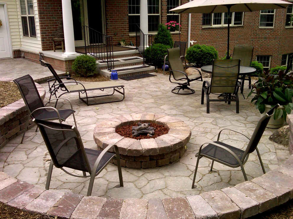 Mid-sized elegant backyard stone patio photo in Cedar Rapids with a fire pit and no cover