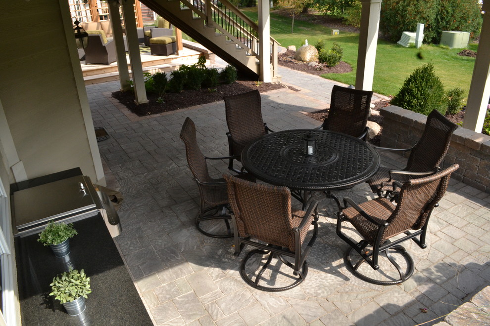 Пример оригинального дизайна: двор среднего размера на заднем дворе в классическом стиле с летней кухней, покрытием из каменной брусчатки и навесом