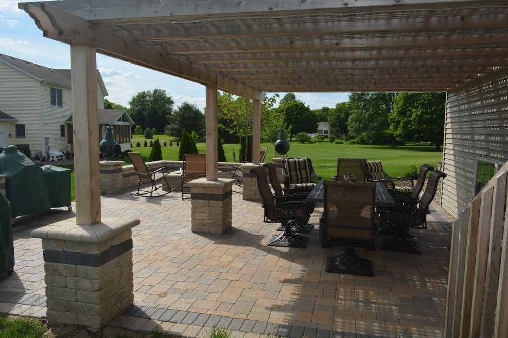This is an example of a medium sized classic side patio in Chicago with concrete paving, an awning and a fire feature.