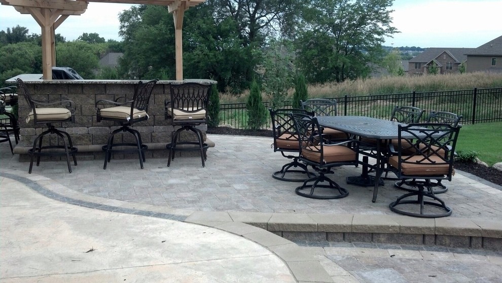 Medium sized traditional back patio in Omaha with an outdoor kitchen, concrete paving and a pergola.