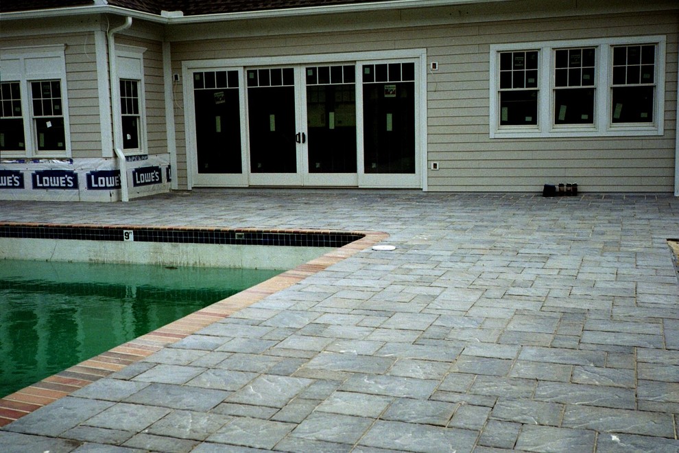 Immagine di un grande patio o portico minimalista dietro casa con pavimentazioni in cemento