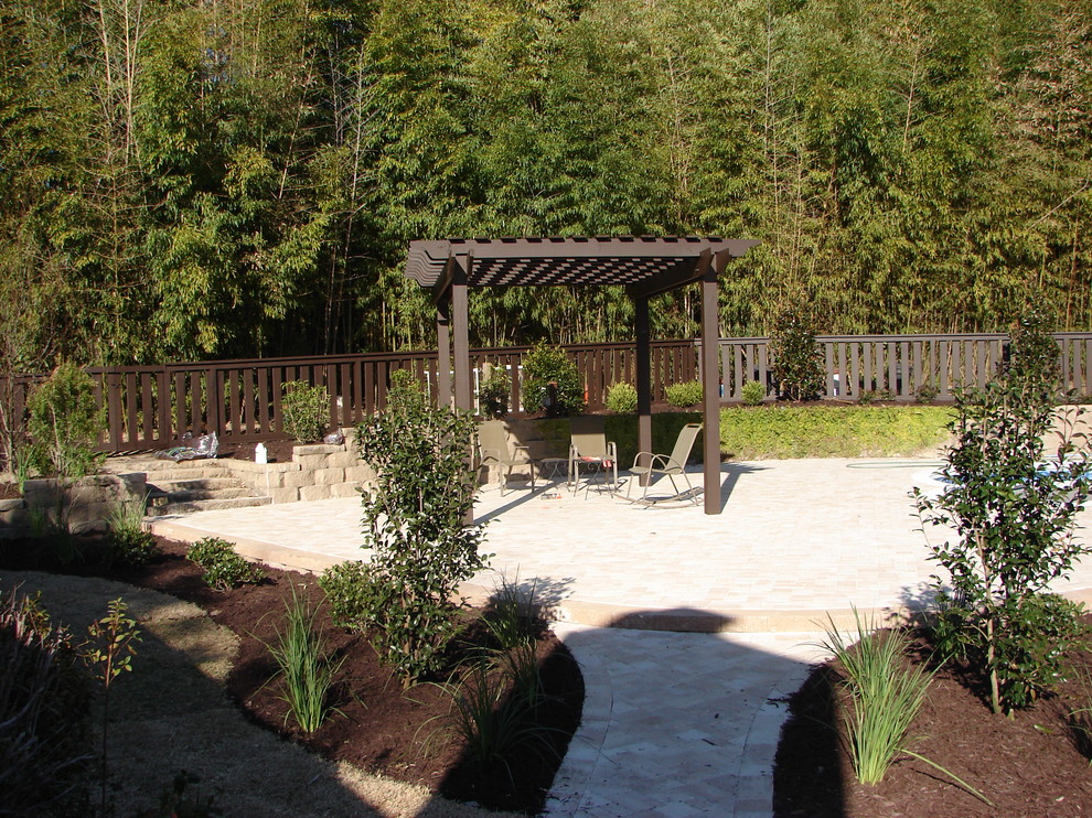 Foto di un patio o portico tradizionale di medie dimensioni e dietro casa con pavimentazioni in cemento e una pergola