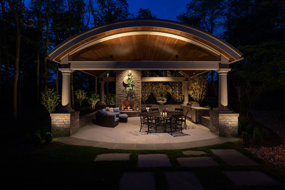 Diseño de patio tradicional de tamaño medio en patio trasero con cocina exterior, adoquines de piedra natural y cenador
