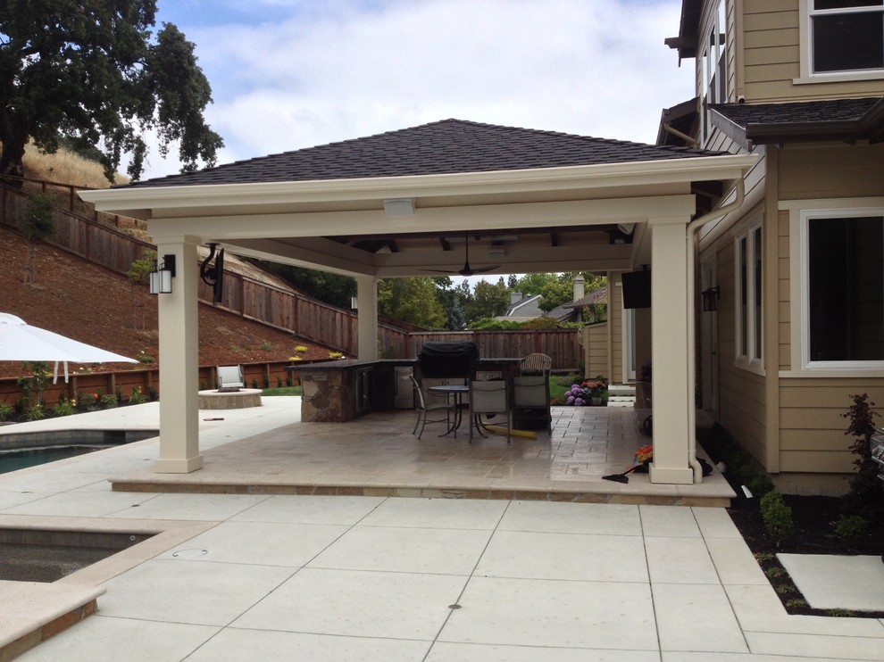 Diseño de patio de estilo americano de tamaño medio en patio trasero con cocina exterior, suelo de hormigón estampado y toldo