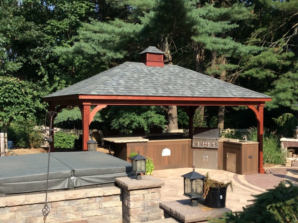 Design ideas for a large classic back patio in Boston with an outdoor kitchen, natural stone paving and a gazebo.