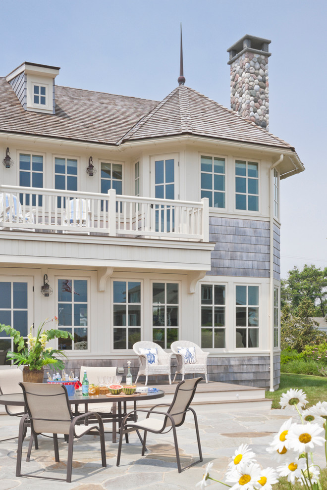 Example of a large ornate backyard stone patio design in Boston with no cover