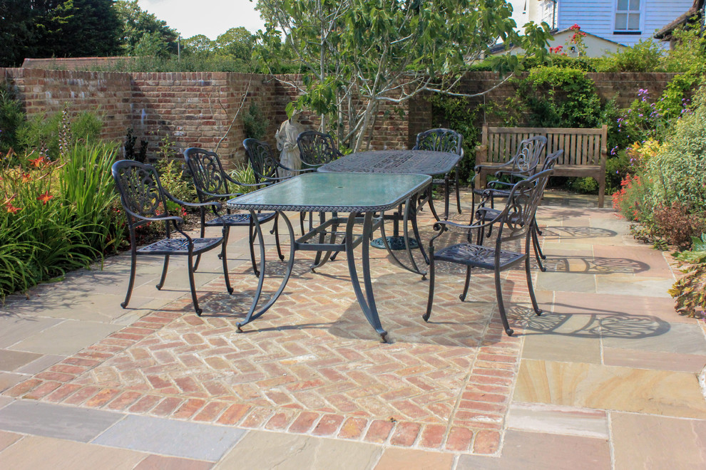 Design ideas for a medium sized contemporary patio in Sussex with natural stone paving.