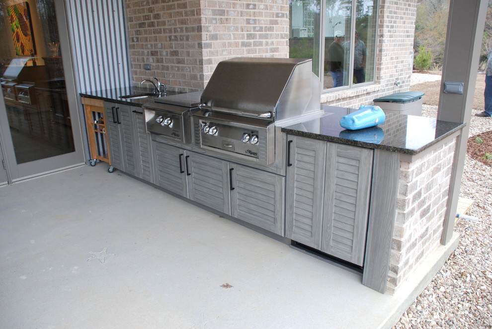 Inspiration for a mid-sized timeless backyard concrete paver patio kitchen remodel in New Orleans with a pergola