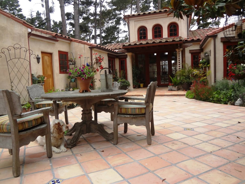 Imagen de patio mediterráneo de tamaño medio sin cubierta en patio trasero con suelo de baldosas