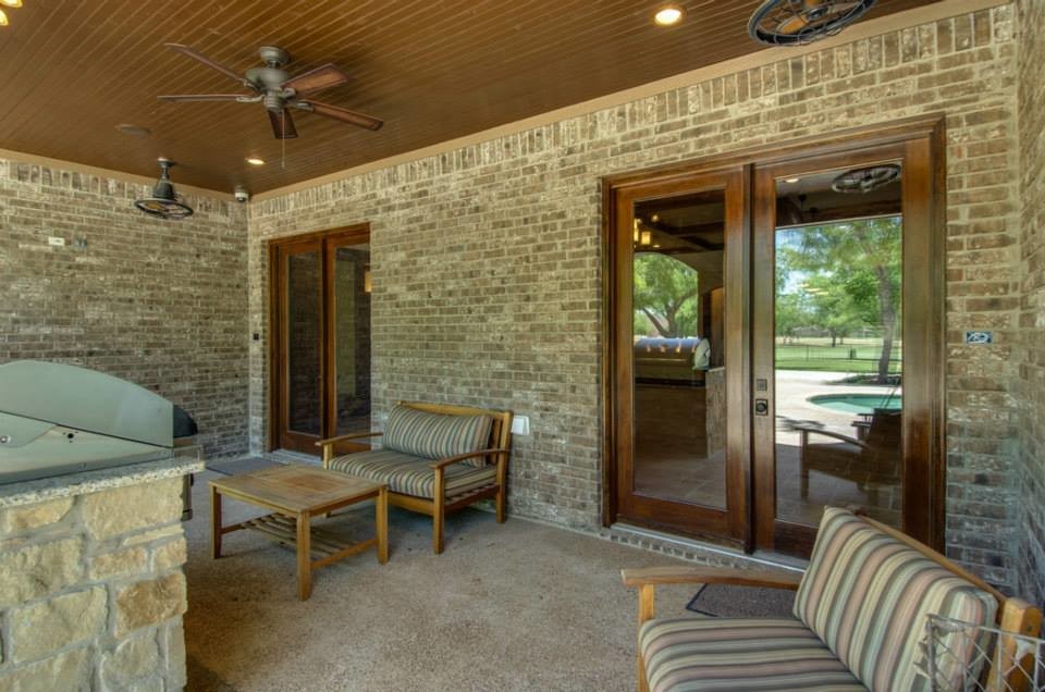 Inspiration pour une terrasse arrière chalet de taille moyenne avec une cuisine d'été, du béton estampé et une extension de toiture.