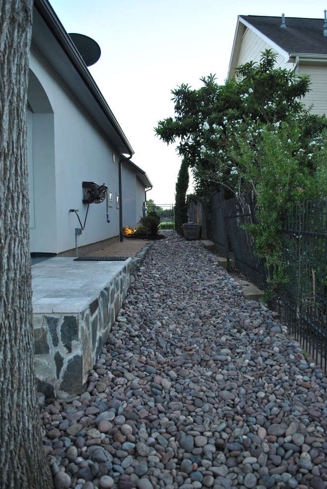 Réalisation d'une terrasse avec des plantes en pots latérale design de taille moyenne avec des pavés en pierre naturelle et une extension de toiture.