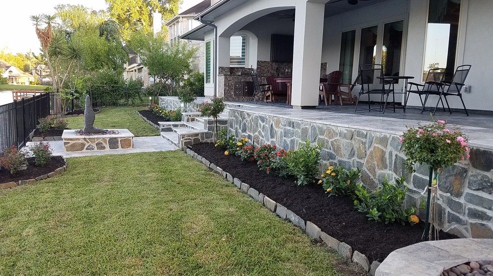 Immagine di un patio o portico minimal di medie dimensioni e dietro casa con un giardino in vaso, pavimentazioni in pietra naturale e un tetto a sbalzo
