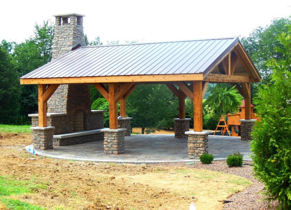 Esempio di un grande patio o portico stile rurale dietro casa con un focolare, lastre di cemento e una pergola