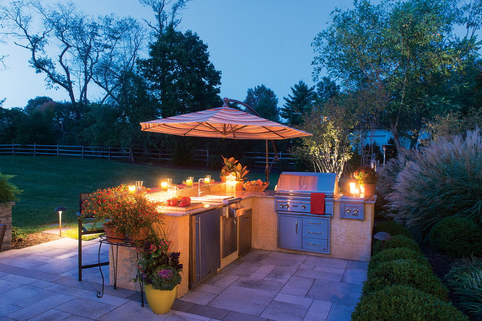 Ejemplo de patio minimalista de tamaño medio en patio trasero con cocina exterior, adoquines de hormigón y toldo