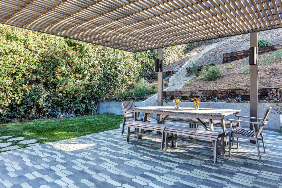 Medium sized farmhouse back patio in Los Angeles with tiled flooring and an awning.