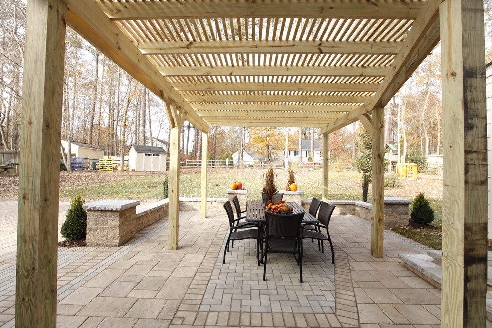Immagine di un grande patio o portico classico dietro casa con pavimentazioni in cemento e una pergola