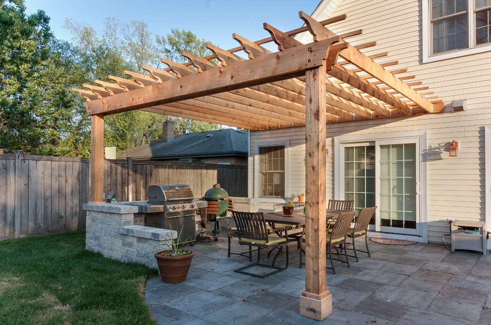 Design ideas for a traditional back patio in Chicago with an outdoor kitchen and a pergola.