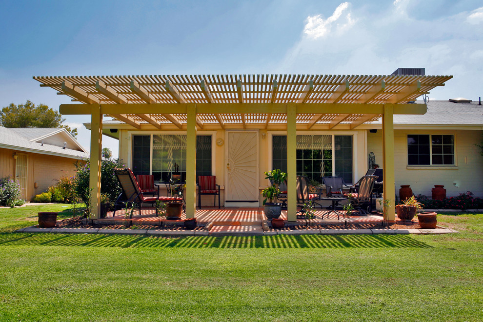 Immagine di un patio o portico tradizionale di medie dimensioni e dietro casa con pavimentazioni in mattoni e una pergola