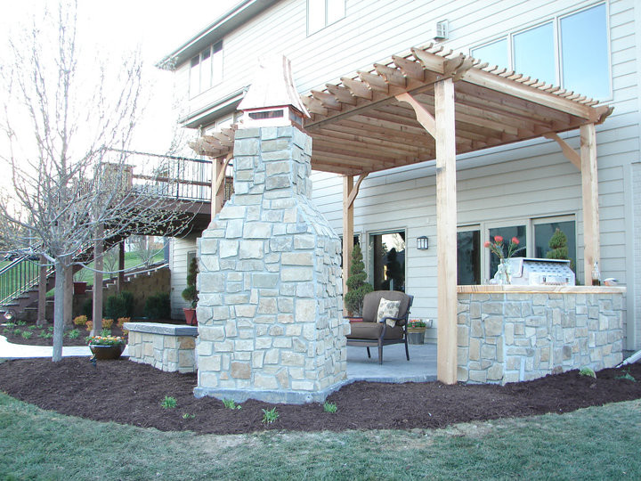 Example of a patio design in Other with a pergola