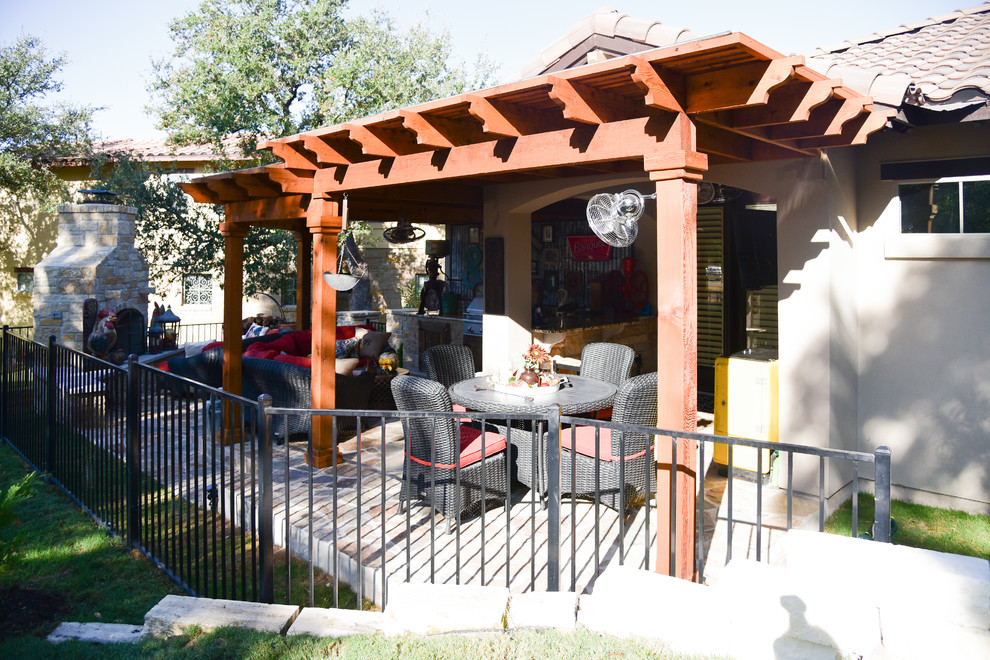 This is an example of a medium sized shabby-chic style back patio in Austin with an outdoor kitchen, concrete slabs and a pergola.