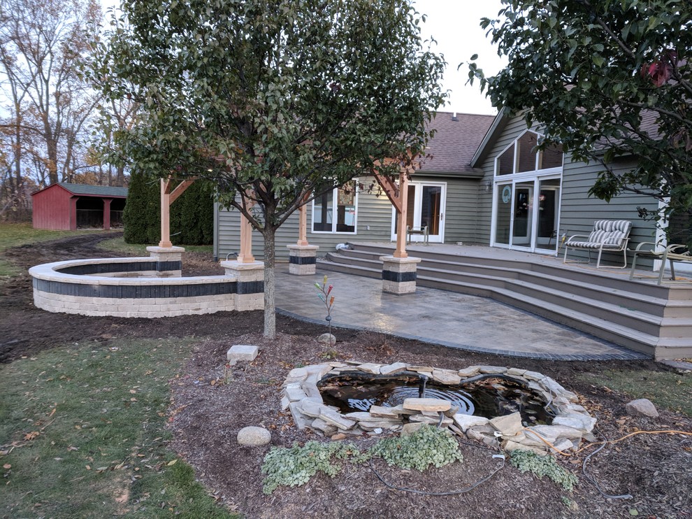 Imagen de patio tradicional renovado de tamaño medio en patio trasero con brasero, pérgola y suelo de hormigón estampado