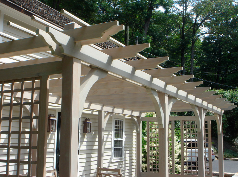 Esempio di un patio o portico country di medie dimensioni e davanti casa con pavimentazioni in pietra naturale e una pergola
